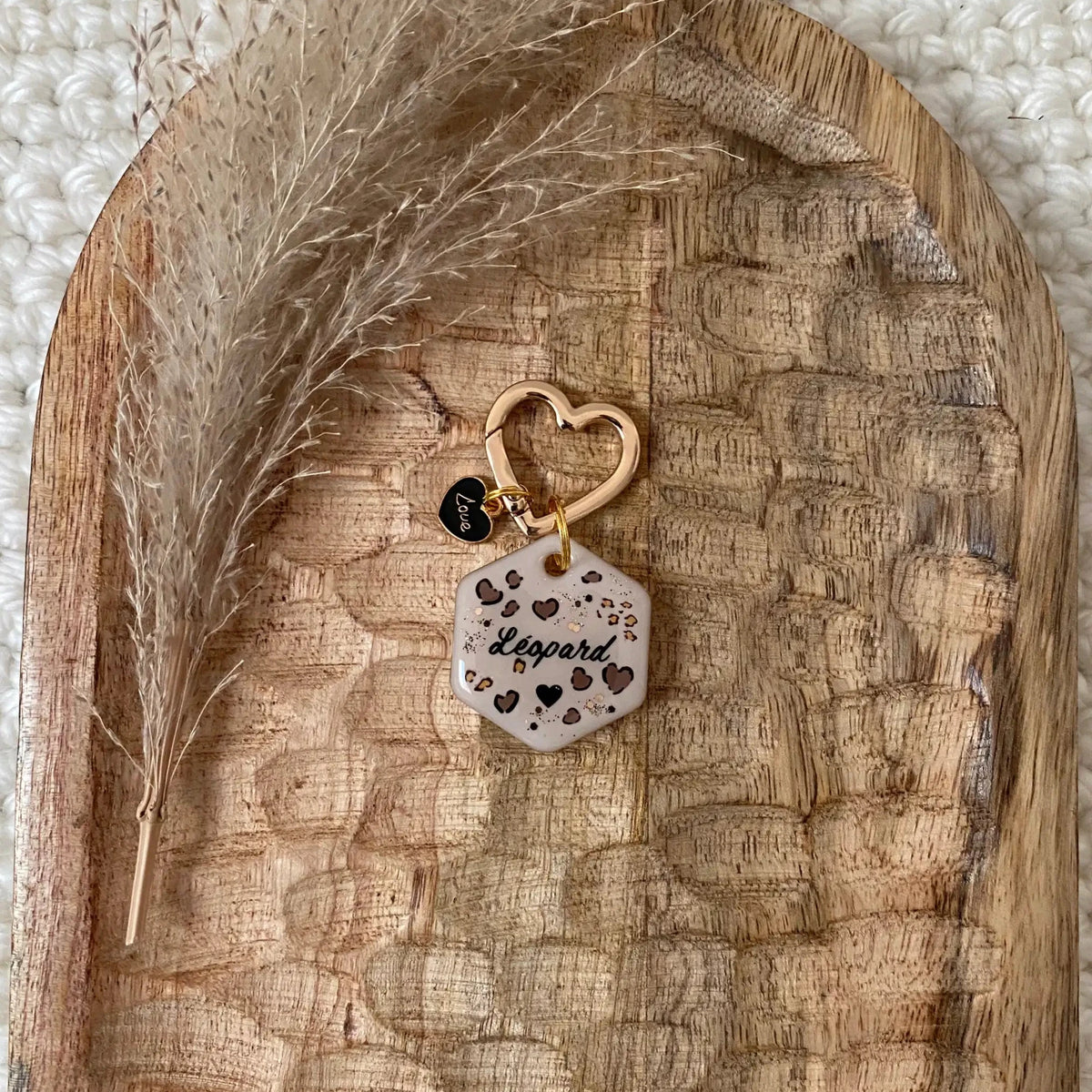 Médaille pour chien faite main en Alsace au motif léopard tendance posée sur un support en bois sculpté