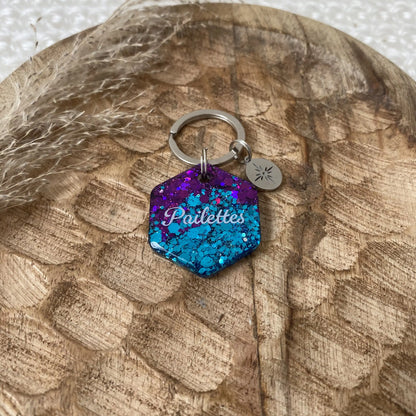 Détail de la résine et des paillettes étincelantes violettes et turquoise captant la lumière