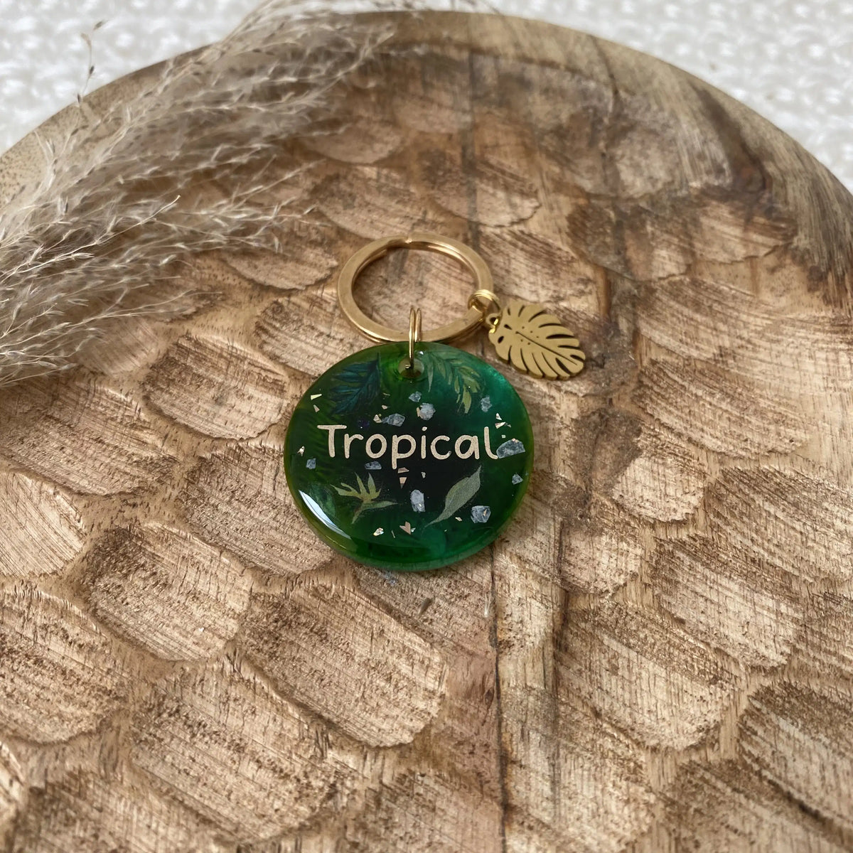 Détail des motifs botaniques et des éclats irisés sur résine vert émeraude